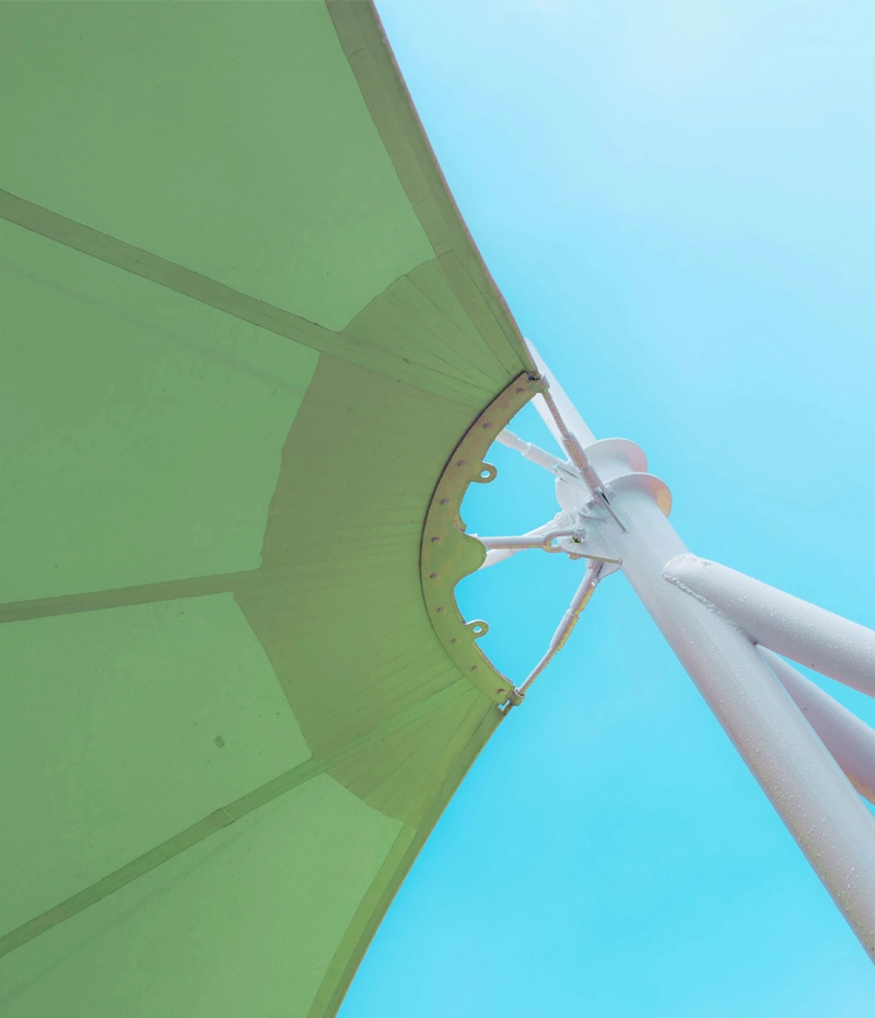 Toldo verde bajo el cielo azulado con estructura metálica